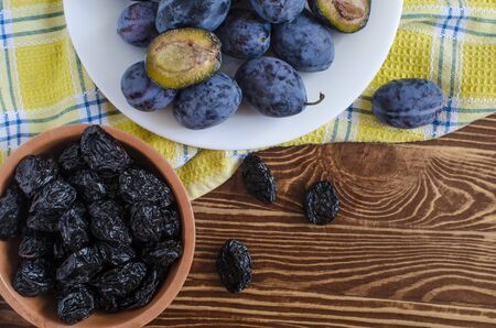 plum and dried plum on a wooden background top view prunesの写真素材