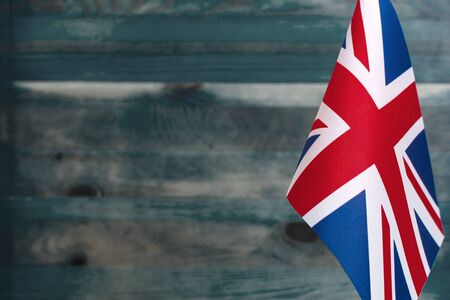 Fragment of the flag of great Britain in the foreground blurred wooden background place under the textの写真素材