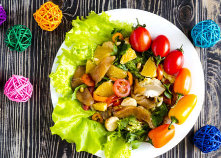 appetizer with fish and vegetables on a white plate decorated with tomatoes, herbs and sweet peppers on a dark wooden background top viewの写真素材