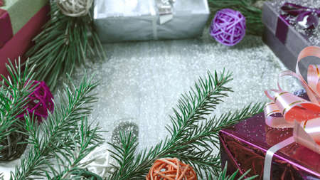 Christmas decorations colored gift boxes green fir branches on a wooden background copy the space...