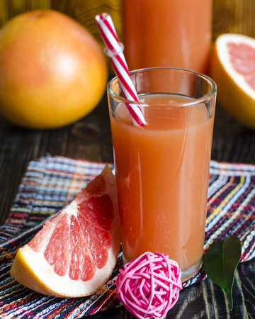 fresh grapefruit juice in a clear high glass slices of grapefruit close upの写真素材