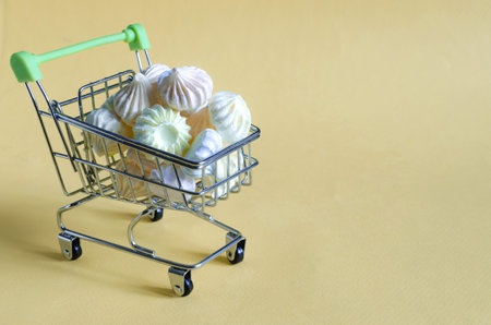 colorful meringue cakes in a metal cart close-up side view of the pastryの写真素材