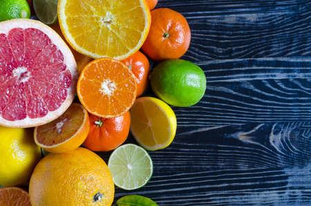 tangerines lemons oranges limes citrus fruits close up on a wooden background kopi spaceの写真素材