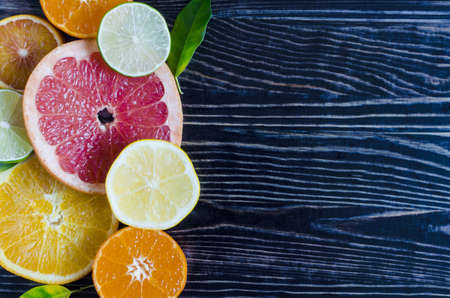 tangerines lemons oranges limes citrus fruits close up on a wooden background kopi spaceの写真素材