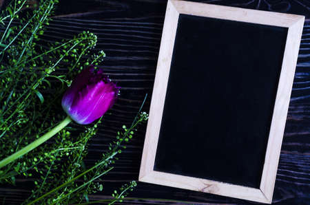 Flatley floral arrangement of lilac tulip and greenery on a dark wooden background slate for text