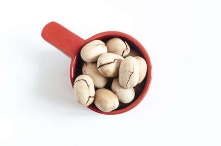large pecans in a brown dish on a white background close up