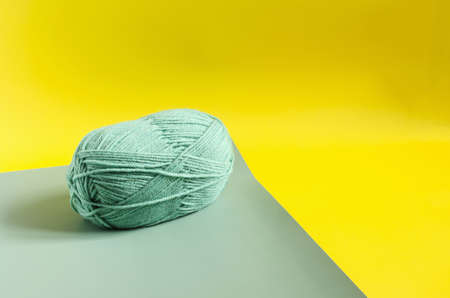 a skein of green yarn on a colored background close up knitting in self isolation