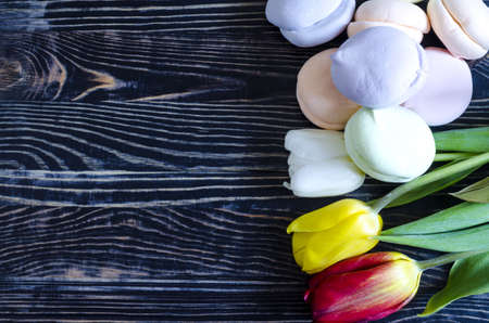 floral arrangement of multicolored tulips with airy cakes on a dark wooden backgroundの写真素材