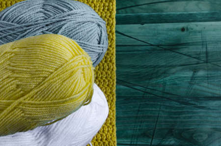 skeins of colored yarn on a colored wooden background top view knitting concept