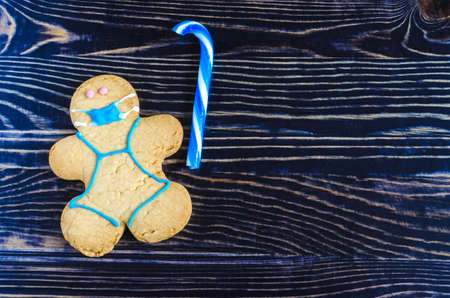 figure of a masked man cookies with blue candy on a dark wooden background sweet dessert figure of a...