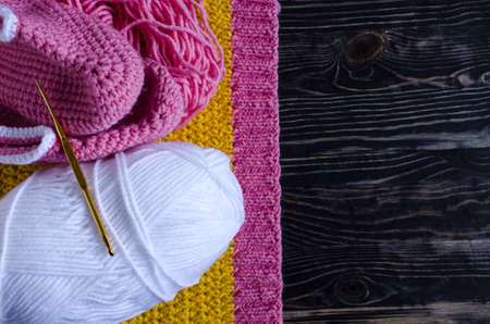 knitting accessories a skein of yarn a knitting hook and a knitting blank on a dark wooden background needlework on a background of self isolation a place for textの写真素材