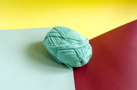 a skein of green yarn on a colored background close up knitting in self isolationの写真素材