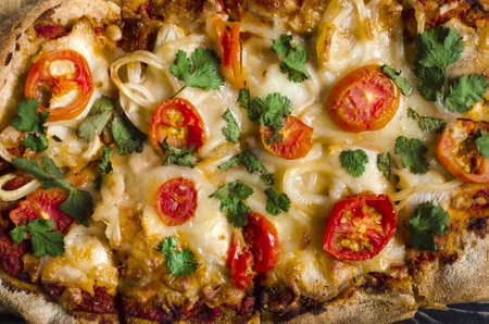 Pinsa with tomatoes and herbs on a colored background close-up. Pinsa home cooking.