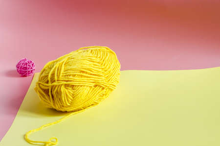 skein of yellow yarn on a colored background close-up knitting in self-isolation