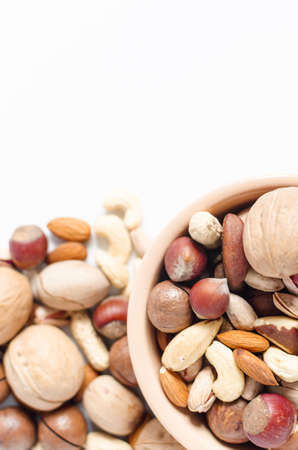 assorted nuts in ceramic dishes and nuts scattered on a white background top view assorted nuts