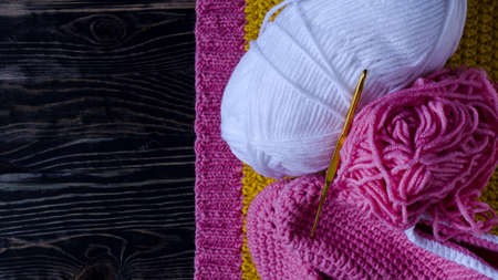 knitting accessories a skein of yarn a knitting hook and a knitting blank on a dark wooden background needlework on a background of self isolation a place for textの写真素材