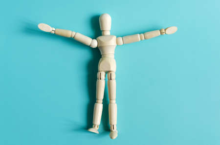 The figure of a wooden man in close-up on a colored background. Figure of a wooden man on a light background of copy spaceの写真素材