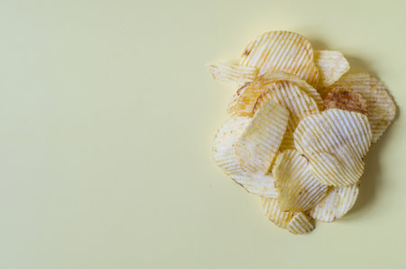 Fluted potato chips close-up on a colored background. Potato chips on a yellow background copy space
