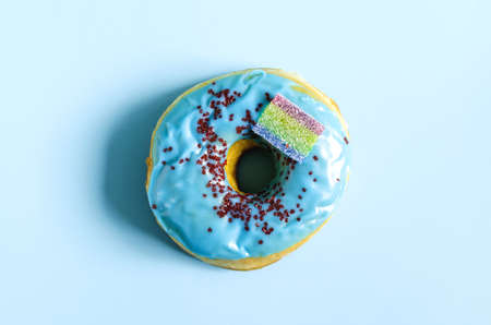 A donut with blue icing on a blue background. A sweet donut on a light background of the kopi spaceの写真素材