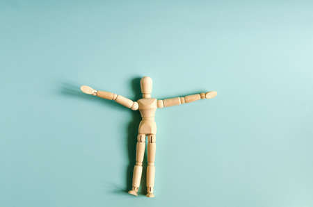 The figure of a wooden man in close-up on a colored background. Figure of a wooden man on a light background of kopi spaceの写真素材