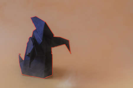 The figure of a dark ghost with a red glow on a red background is the place for the text. Dark paper ghost for the Halloween holidayの写真素材