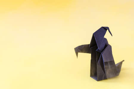 The figure of a dark ghost on a yellow background is a place for text. A dark paper ghost for the Halloween holidayの写真素材