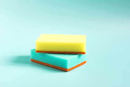 Colored porous sponges for cleaning and washing dishes close-up on a blue backgroundの写真素材