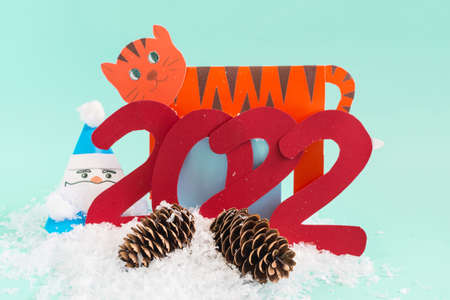 A bright New Year's card. Paper tiger, Santa Claus and the numbers 2022 on a bright blue backgroundの写真素材