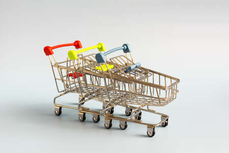 Colored empty metal shopping basket on a light background. The concept of shopping baskets from supermarketsの写真素材