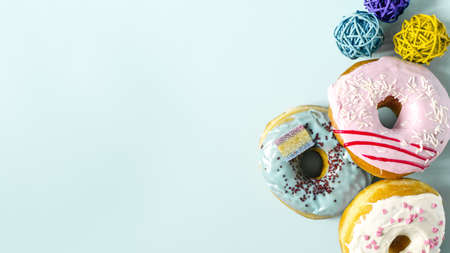 Banner fresh bright donuts with colored glaze and decor on a light background. Colorful donuts close-upの写真素材
