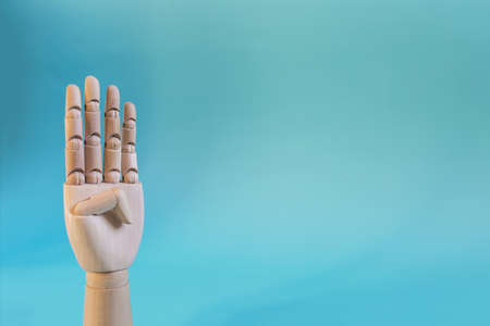 The wooden hand gesture shows four fingers up. The concept is a wooden hand showing the number four close-up on a light backgroundの写真素材
