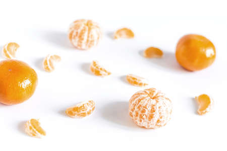 White background with pieces of tangerines and whole tangerines sharpness in the foregroundの写真素材