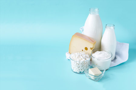 The concept of consumption of dairy products. Milk, kefir, sour cream, cheese, butter and cottage cheese in a glass container with a white towel on a light background place for textの写真素材