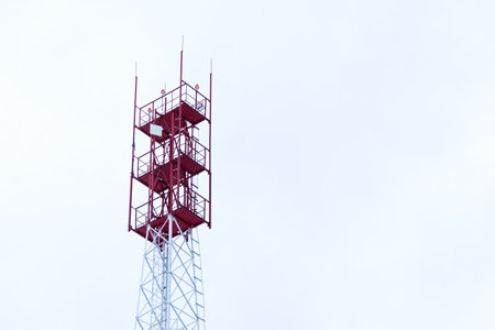 Metal tower with electronic equipment and communication antennas close-up against the sky