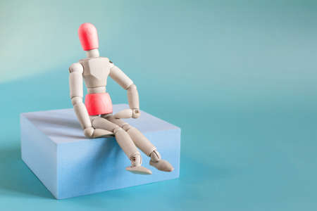 The concept of abdominal diseases. The figure of a wooden man on a blue podium with a belly and head highlighted in red.の写真素材