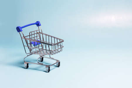 Blue empty metal basket on a blue background. The concept of sales and trade..