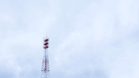 Metal tower with electronic equipment and communication antennas close-up against the skyの写真素材