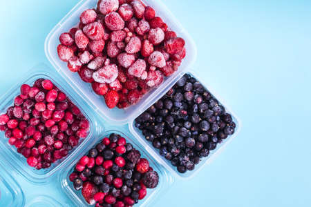 Frozen strawberries blackberries cranberries and currants with ice crystals on a light background top viewの写真素材