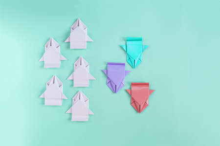 The concept of colored paper machines moving in the opposite direction from the nondescript white machines on a colored background top view.の写真素材