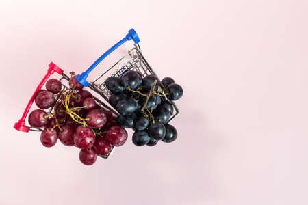 Grapes of red and black in grocery baskets top view.の写真素材