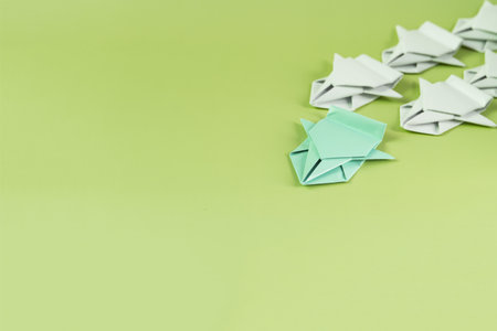 The concept of competition. Colored Paper origami Machine ahead of white origami machinesの写真素材