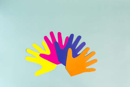Abstract background open palms made of colored paper on a blue background.