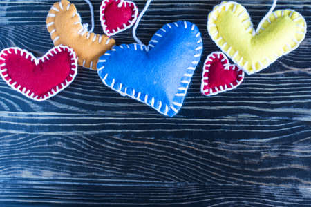 Background of colored plush hearts sewn with white threads of copy space.の写真素材