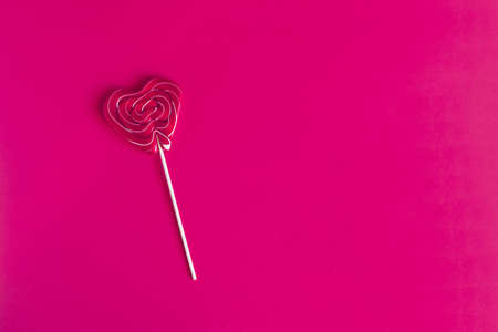 A bright red lollipop on a red background is a place for text.の写真素材