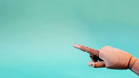 The banner is a wooden mannequin hand with an outstretched index finger pointing at a large empty space of the copy space.の写真素材