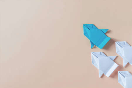 The concept of competition in business. The colored paper origami machine is ahead of the usual white copy space machinesの写真素材