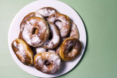 Fresh homemade donuts with white sprinkles close-up on a white plate.の写真素材