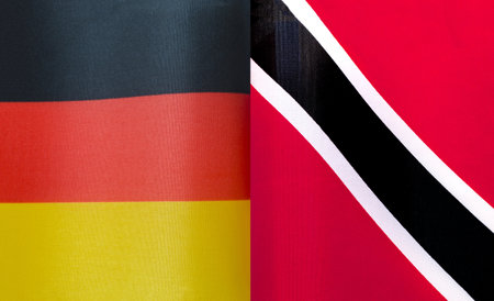 fragments of the national flags of Germany and Trinidad and Tobago close-upの写真素材