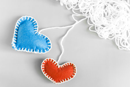 Soft blue and red rag hearts on a light background close-up copy space.