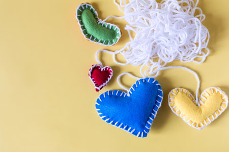 Abstract background a ball of white threads with colored hearts on a yellow background.の写真素材